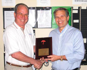 Vecellio Group V.P. of Safety John West, left, presents Ranger South President Hazen Hinds with a plaque from Travelers honoring the divisions impressive no lost time accomplishments.
