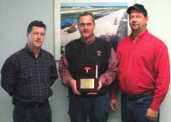 Steve Beals from Travelers, left, presents Sharpe Bros. V.P. Ivan Clayton, center, and Safety Director John Riley, Jr., with a plaque recognizing Sharpe Bros. two years without a lost time incident.