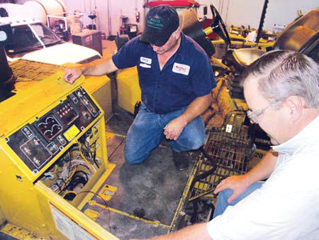 Sharpe Bros. Lead Mechanic Danny Primm chats with consultant Mark Lucas about Product Link, which is installed on Vecellio Group equipment to wirelessly send details to management when a component needs attention. (Photo by Carl Thiemann)