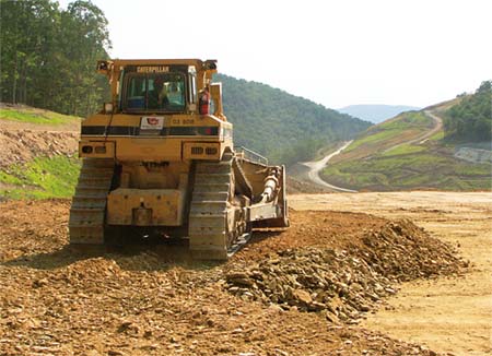 Dozer Operator Harold Eye spreads excess fill material in a waste area. In the background are temporary haul roads and access roads along the upper edges of V&G's Corridor H project in Grant County, WV. (Photo by Carl Thiemann)