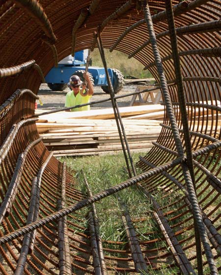 Crane Operator Lee Roberts inspects lumber next to a rebar cage on V&G's Corridor H project in Grant County, WV. (Photo by Carl Thiemann)